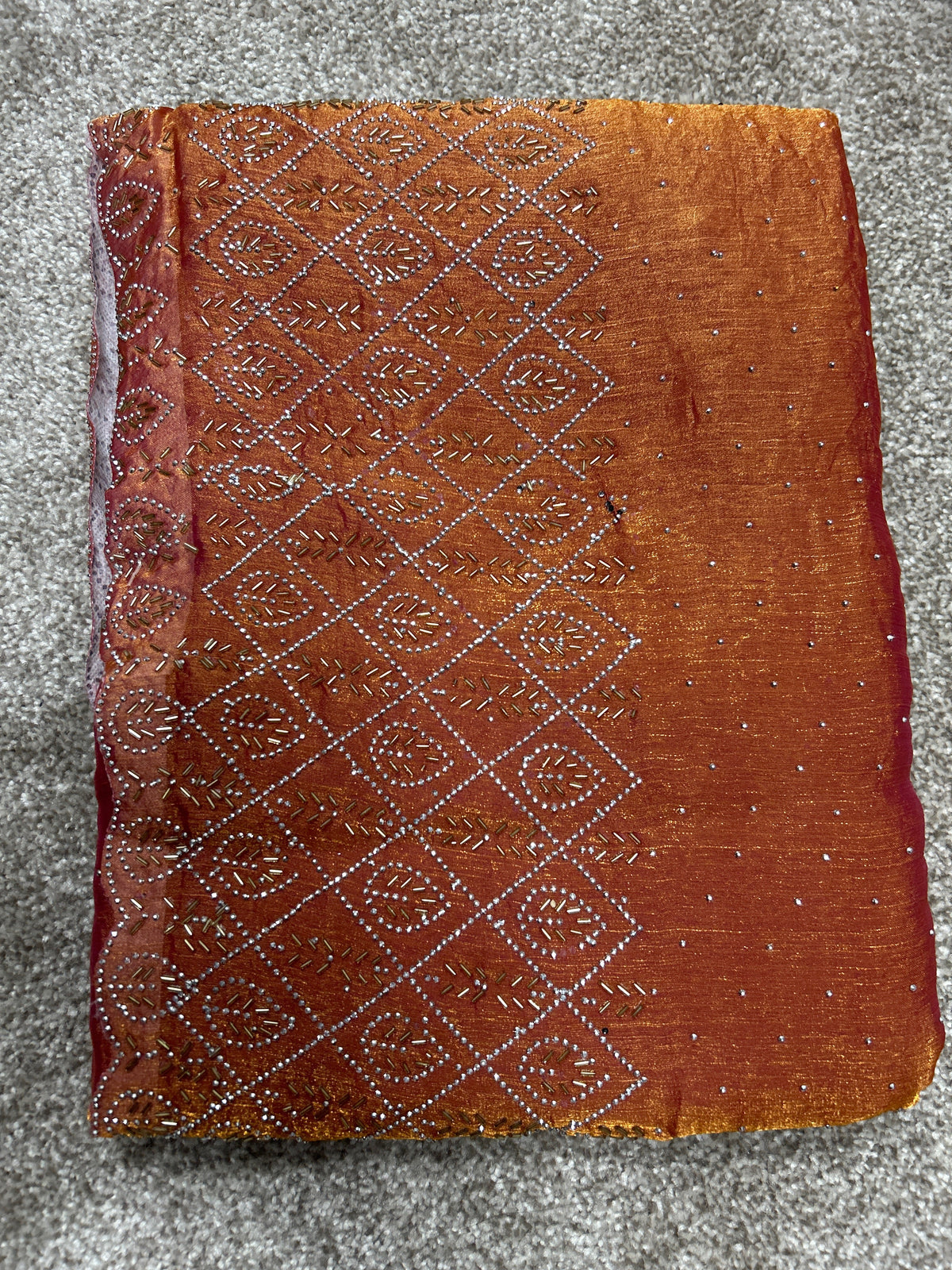 Orangefarbener Saree mit goldfarbenen Verzierungen